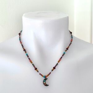 Dark colorful beaded necklace with silver tone crescent moon charm pendant